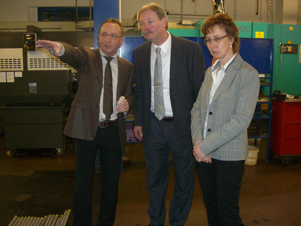 Benno Kaufhold (Mitte) mit der Gesch&auml;ftsleitung Gerd und Anke Sauerbrey in der Fertigung