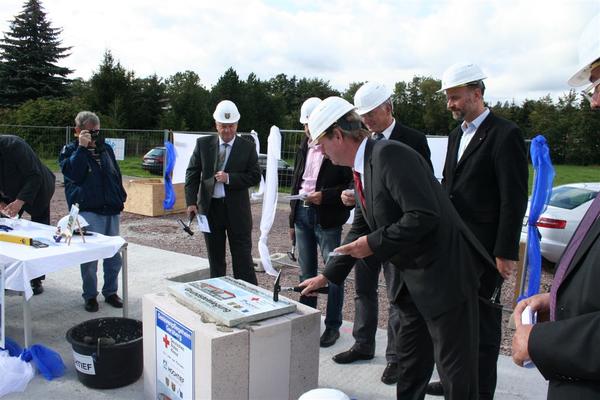 Landrat Dr. Kaufhold vollzieht den zweiten Hammerschlag auf dem Baufeld in Geraberg
