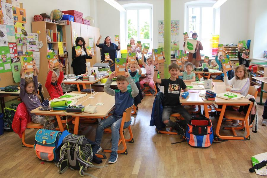 Die Fuchsklasse, Landr&auml;tin Petra Enders, Schulleiterin Franziska Sch&ouml;n und Klimaschutzmanager Felix Schmigalle mit den M&ouml;hrchenheften und Jutebeuteln.