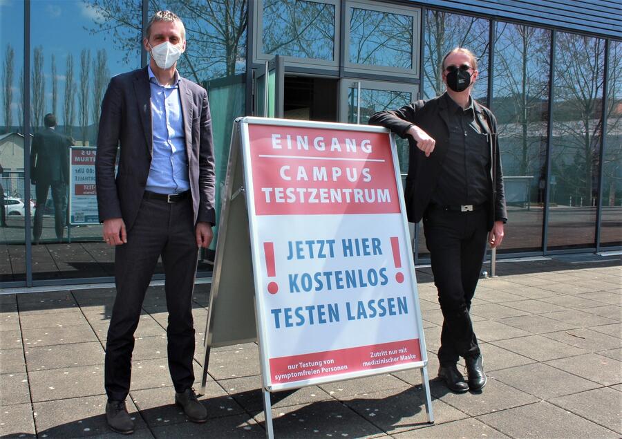 Rektor Prof. Kai-Uwe Sattler und Beigeordneter Kay Tischer vor dem Testzentrum in der Campussporthalle der TU Ilmenau.
