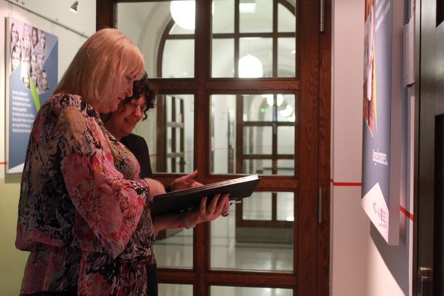 Liudmilla Baum aus Wei&szlig;russland zeigt Petra Enders ihre Zeichungen.